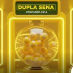 Equipamento de sorteio da Dupla Sena com iluminação laranja intensa, destacando o concurso 2914 e bolas de loteria em rotação.
