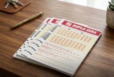 Resultado da Dupla Sena 2930: confira os números sorteados nesta sexta-feira (27) 33 Pilha de volantes da Dupla Sena sobre mesa de escritório ao lado de uma caneta dourada e chaves.