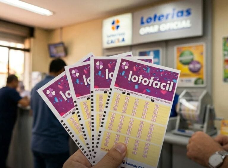 Mão segurando vários volantes da Lotofácil dentro de uma unidade das Loterias Caixa.