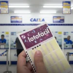 Bilhete da Lotofácil sendo segurado dentro de uma agência da CAIXA