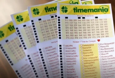 Resultado da Timemania 2359: Ninguém acerta 7 dezenas e prêmio acumula em R$ 8,5 milhões 15 Quatro volantes de apostas da Timemania em leque sobre uma mesa de madeira escura com iluminação clara e nítida.
