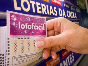 Foto de uma mão pegando um bilhete da Lotofácil em lotérica