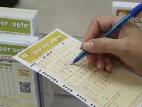Pessoa marcando os números de um bilhete da Dia de Sorte em uma mesa de vidro