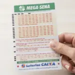 Mão segurando bilhete da Mega Sena
