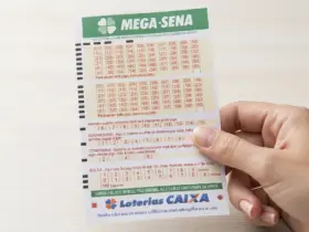 Mão segurando bilhete da Mega Sena
