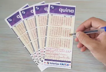 Pessoa marcando números em bilhete da Quina