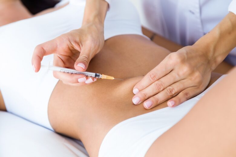 cirurgiao fazendo injecao no corpo feminino conceito de lipoaspiracao