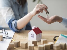 close up woman s hand giving house key man wooden table