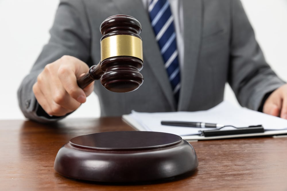 closeup shot person holding gavel tabl