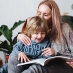 mae e filho sentado e lendo o livro juntos em casa 153585 9