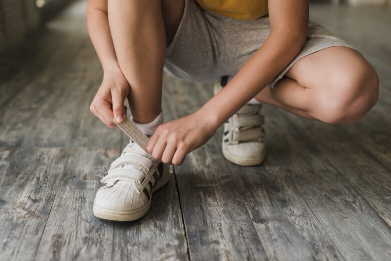 secao baixa de um menino por cinta sapato ligado assoalho hardwood