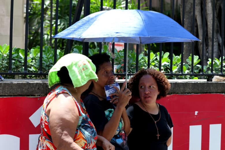 Rio de Janeiro (RJ), 12/11/2023 - Candidatos se protegem do forte calor enquanto aguardam abertura dos portões para o segundo dia provas do Enem 2023, na Universidade Veiga de Almeida, na Tijuca, zona norte da cidade. Foto: Tânia Rêgo/Agência Brasil