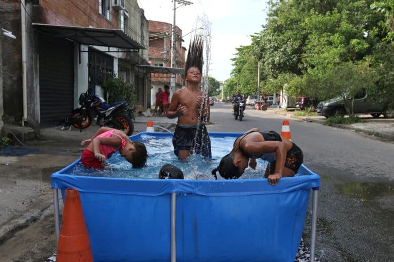 Rio de Janeiro (RJ), 16/11/2023 - Moradores do Complexo da Maré se refrescam com chuveiros e piscinas improvisadas nas ruas da comunidade. A sensação térmica na cidade do Rio de Janeiro voltou a superar os 50 graus Celsius (°C), com a onda de calor que atinge boa parte do Brasil. Foto: Tânia Rêgo/Agência Brasil