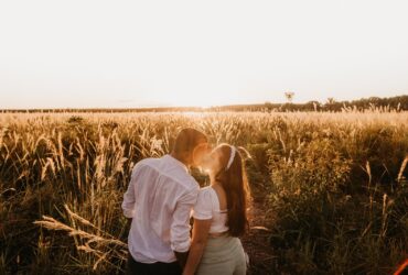 Casal apaixonado beijando no vasto campo ao pôr do sol - Fotos do Canva