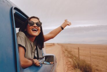 Mulher feliz em uma viagem no carro - Fotos do Canva