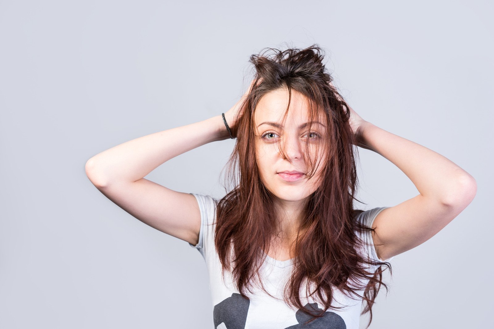 Mulher segurando um cabelo bagunçado, olhando para a câmera - Fotos do Canva