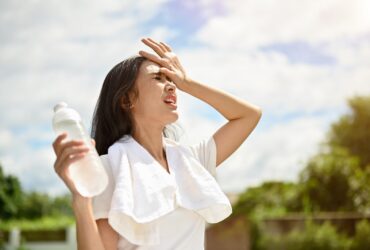 Uma mulher asiática exausta está lutando contra a onda de calor enquanto corre - Fotos do Canva