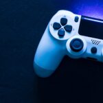 Video Game Controller with Blue Lighting on Dark Background - Fotos do Canva