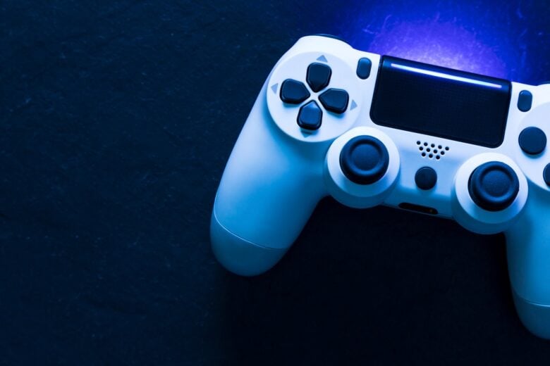 Video Game Controller with Blue Lighting on Dark Background - Fotos do Canva