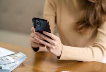 Mulher asiática enviando mensagens de texto verificando mídias sociais segurando smartphone em - Fotos do Canva