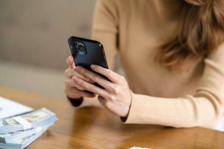 Mulher asiática enviando mensagens de texto verificando mídias sociais segurando smartphone em - Fotos do Canva