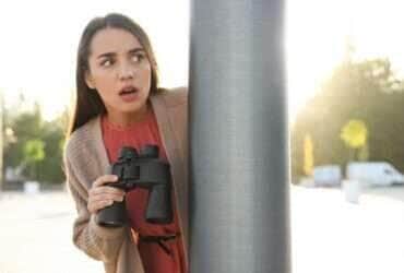 Mulher ciumenta com binóculos espionando ex-namorado ao ar livre - Fotos do Canva