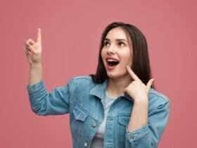 Mulher excitada apontando para cima na ideia - Fotos do Canva