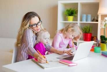 Mulher ocupada tentando trabalhar enquanto cuida de dois filhos - Fotos do Canva