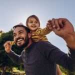 Homem sorridente, brincando com seu filho ao ar livre - Fotos do Canva