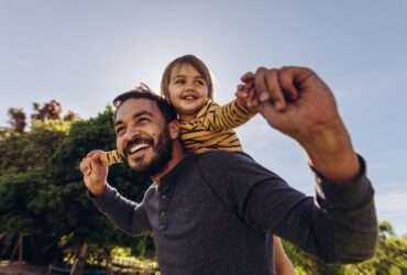 Homem sorridente, brincando com seu filho ao ar livre - Fotos do Canva