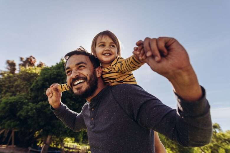 Homem sorridente, brincando com seu filho ao ar livre - Fotos do Canva