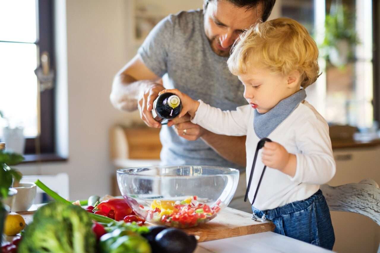 Jovem pai com um menino cozinhando - Fotos do Canva