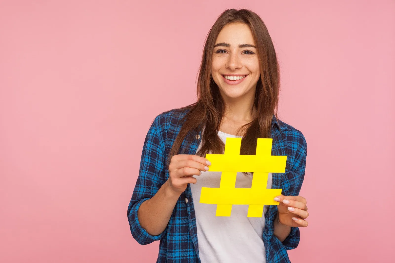 Mulher Segurando Uma Hashtag De Papel Amarelo Em Fundo Rosa - Fotos do Canva1