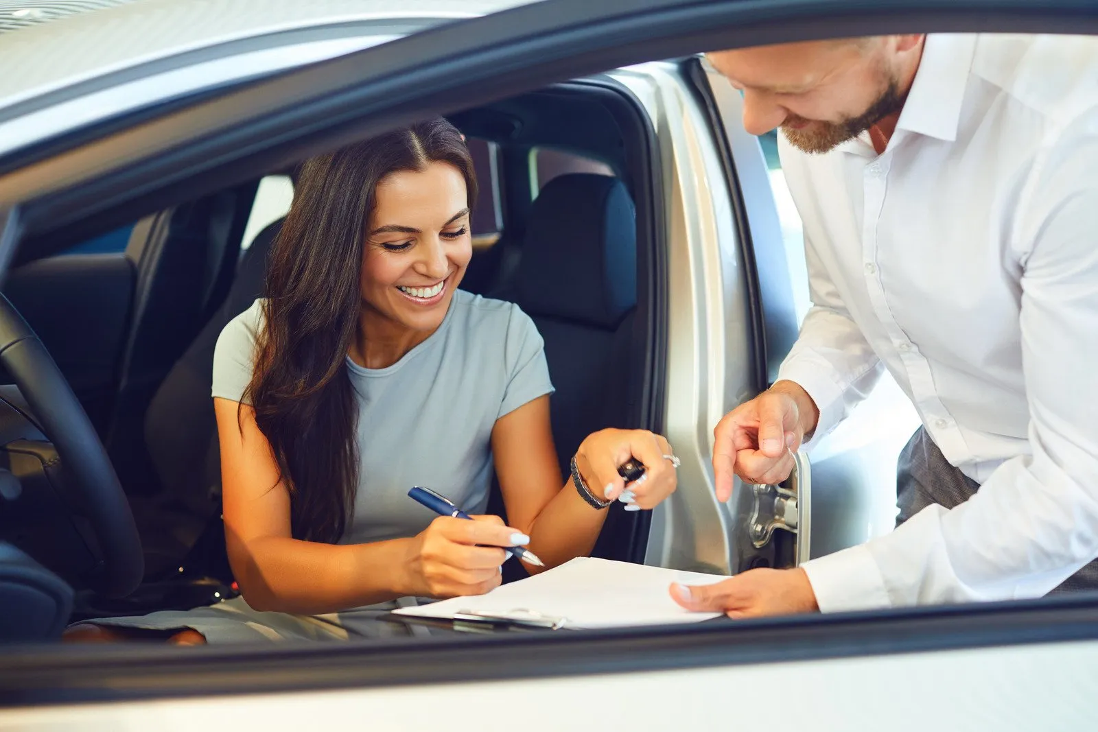 Uma jovem compra um carro em um showroom de carros - Fotos do Canva1