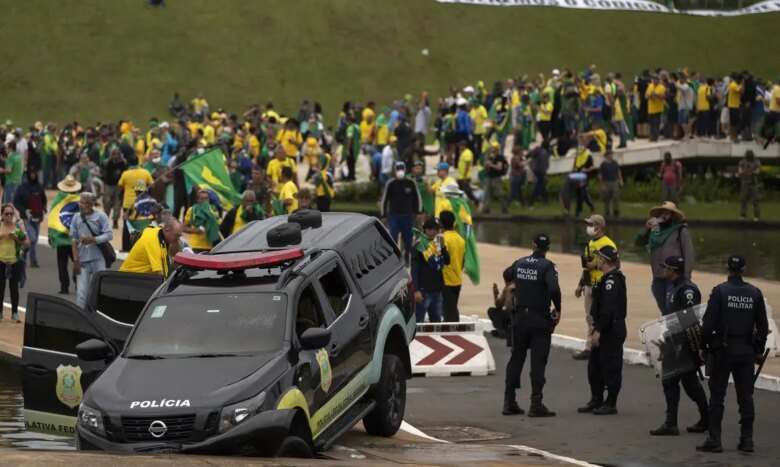 Brasilia (DF) 08/01/2023 - Golpistas invadem prédios públicos na praça dos Três Poderes. Na foto, carros da Polícia Legislativa  são depredados por vândalos em frente ao Congresso Nacional.