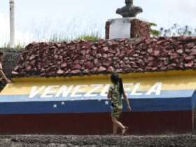 Crianças brincam em marco da fronteira entre Brasil e Venezuela.