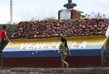 Crianças brincam em marco da fronteira entre Brasil e Venezuela.