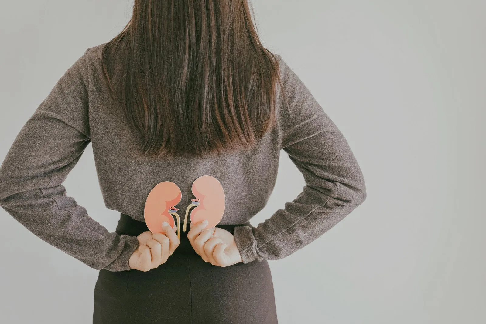 Back view of woman suffering from lower back pain with kidney shape, chronic kidney disease, renal failure concept - Fotos do Canva1