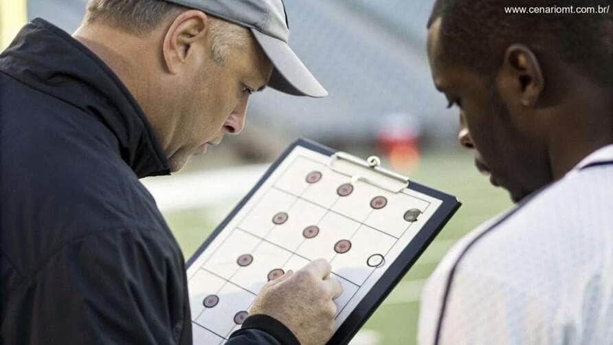 Treinador analisando estatísticas defensivas de Al-Taawoun e Al-Ittihad em um tablet.