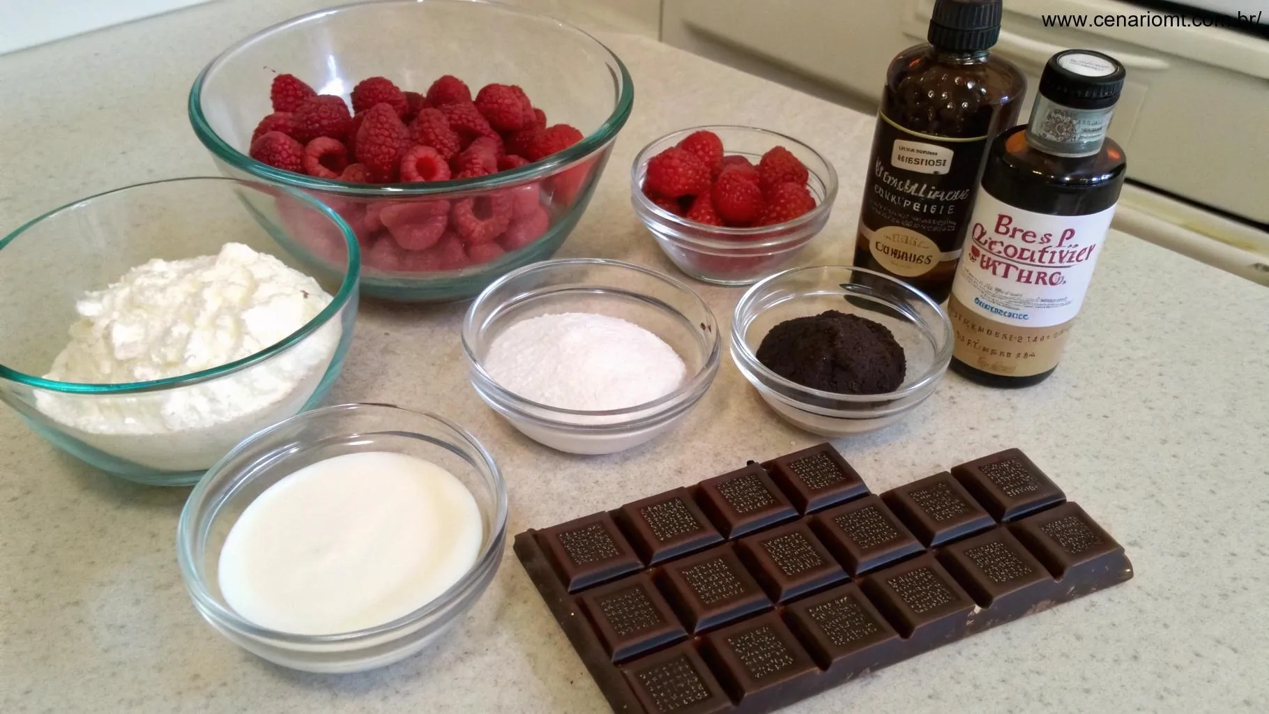 Ingredientes para o pavê de chocolate e framboesa, incluindo framboesas frescas, chocolate, creme de leite e açúcar.