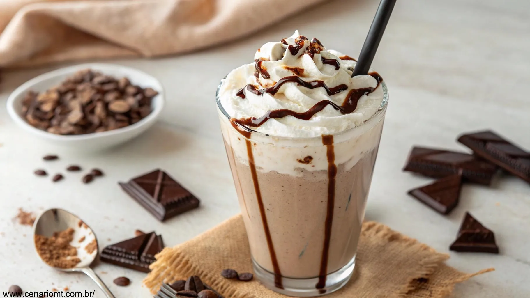 Milkshake de chocolate cremoso servido em um copo alto com chantilly e calda de chocolate por cima.