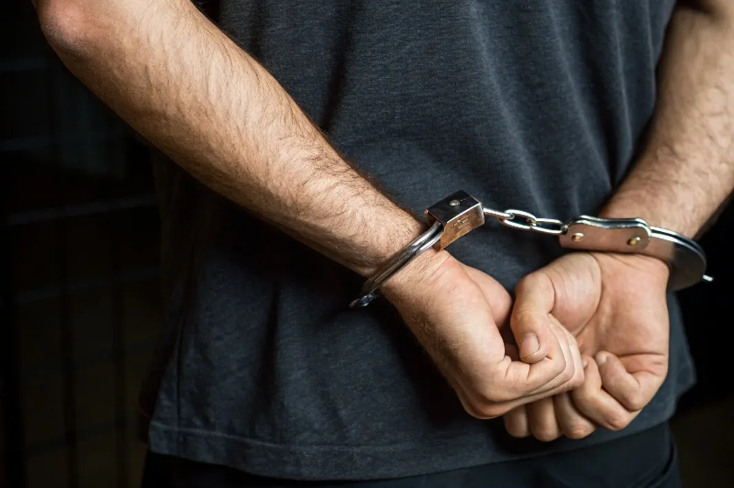 Homem Algemado mãos para traz