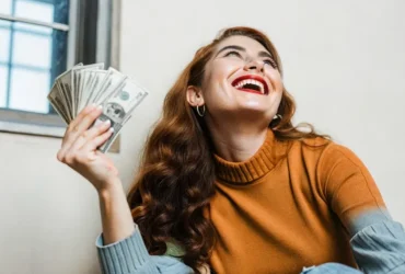 Mulher sorrindo com dinheiro na mão