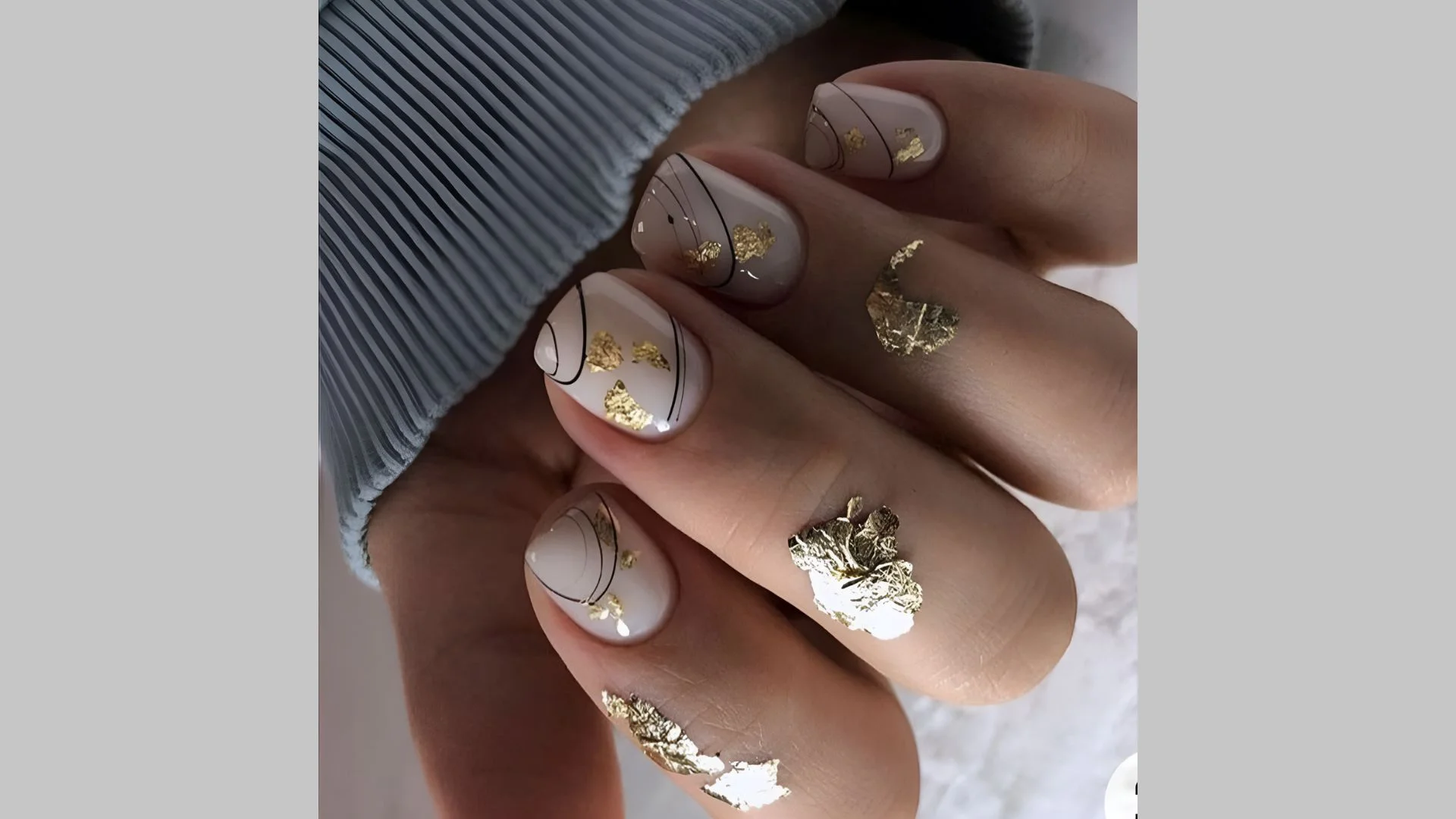 Design de unhas com ouro e efeito teia de aranha.