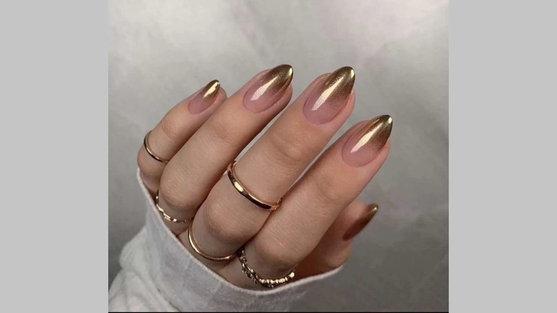 Manicure dourada estilo ombre com transição suave de cor.
