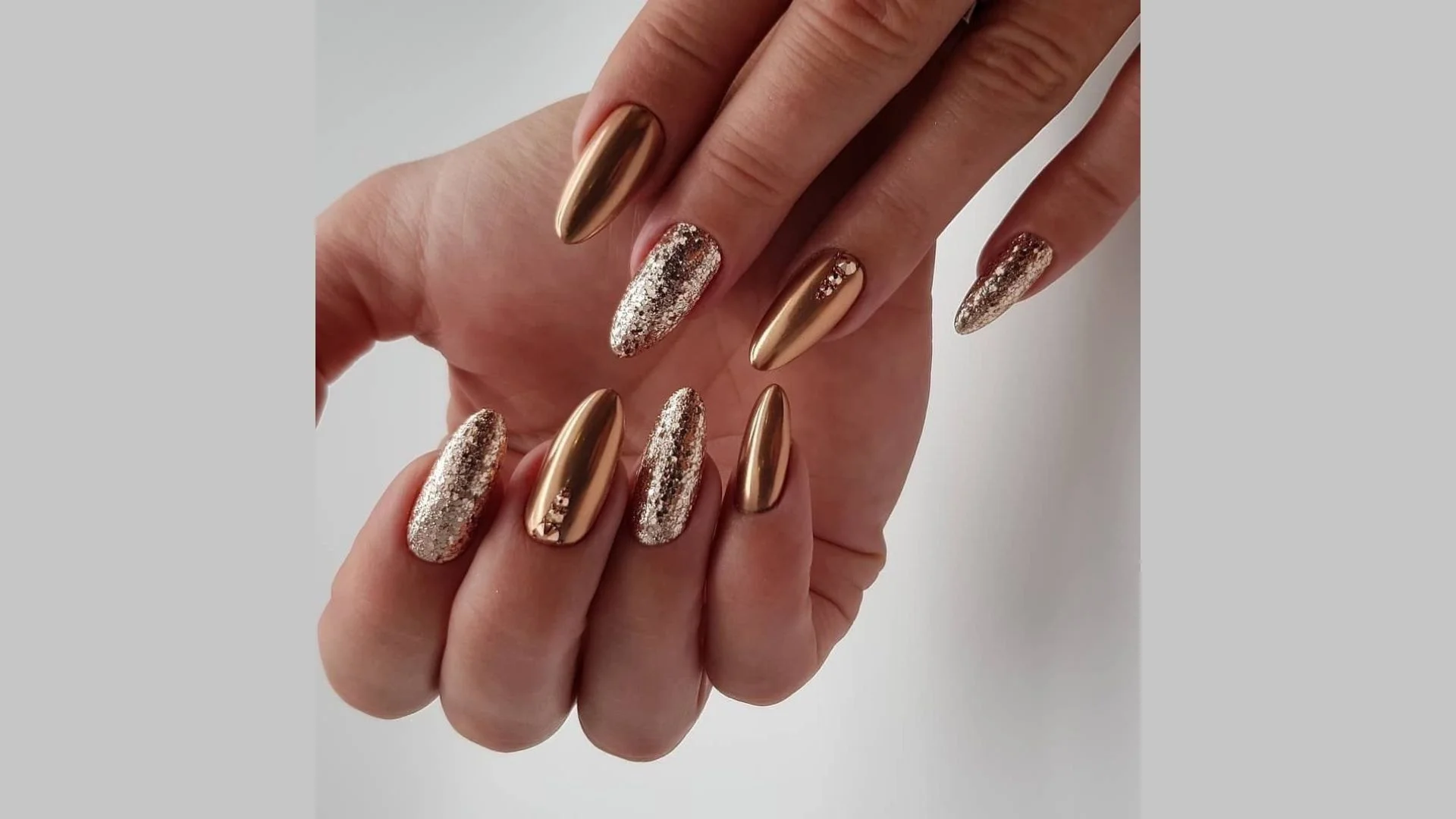 Unhas compridas com design de manicure dourada e efeito ombre.