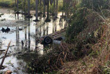 Corpo de Bombeiros resgatou vítimas de carro capotado em área pantanosa e localizou corpo de jovem desaparecido a cerca de 45 metros do veículo