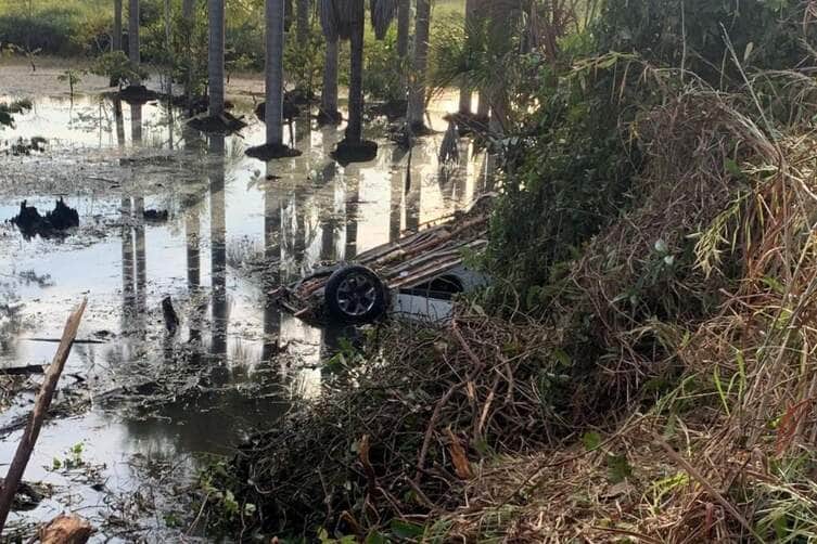 Corpo de Bombeiros resgatou vítimas de carro capotado em área pantanosa e localizou corpo de jovem desaparecido a cerca de 45 metros do veículo