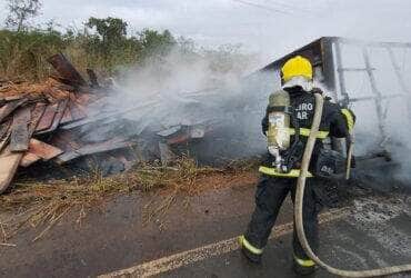 Fogo consumiu a parte frontal da composição na manhã desta segunda-feira; Bombeiros atuam com maquinário para controlar chamas e liberar a rodovia