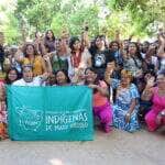 Foto de mulheres indígenas reunidas na TI Japuíra, à beira do rio Juruena, durante assembleia estadual da Fepoimt.